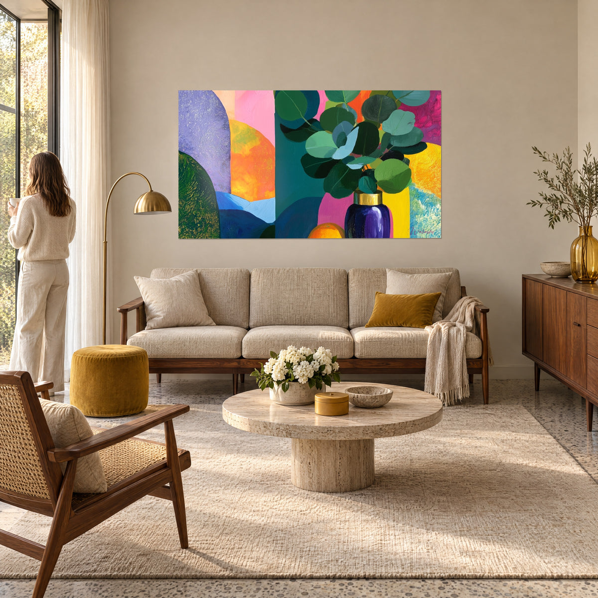 Tableau bouquet d'eucalyptus dans un vase indigo, fond orange et lilas, femme de dos au-dessus d'un canapé dans un salon lumineux