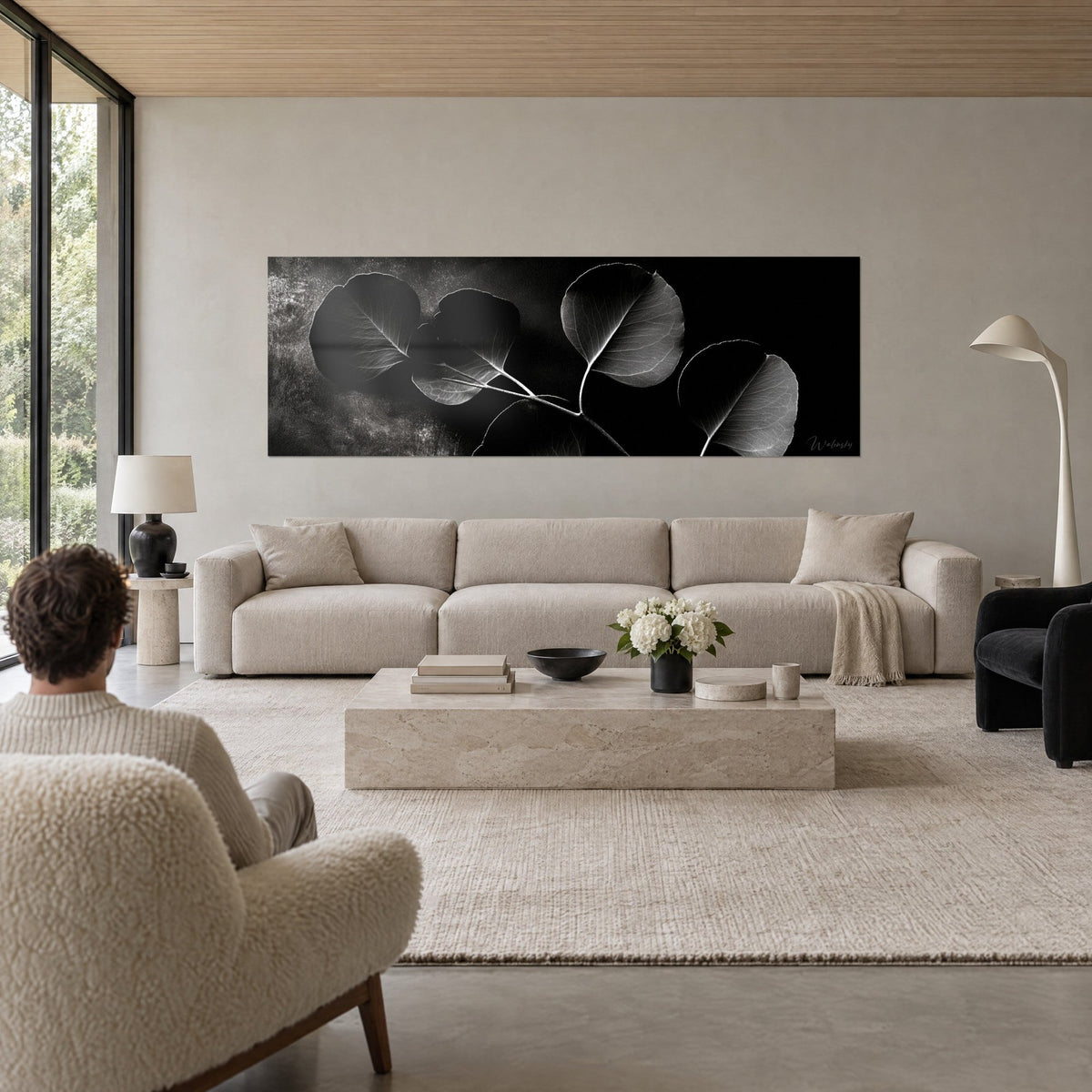 Wall art black and white eucalyptus, round leaves with silver veins on slate background, above a sofa in a bright living room