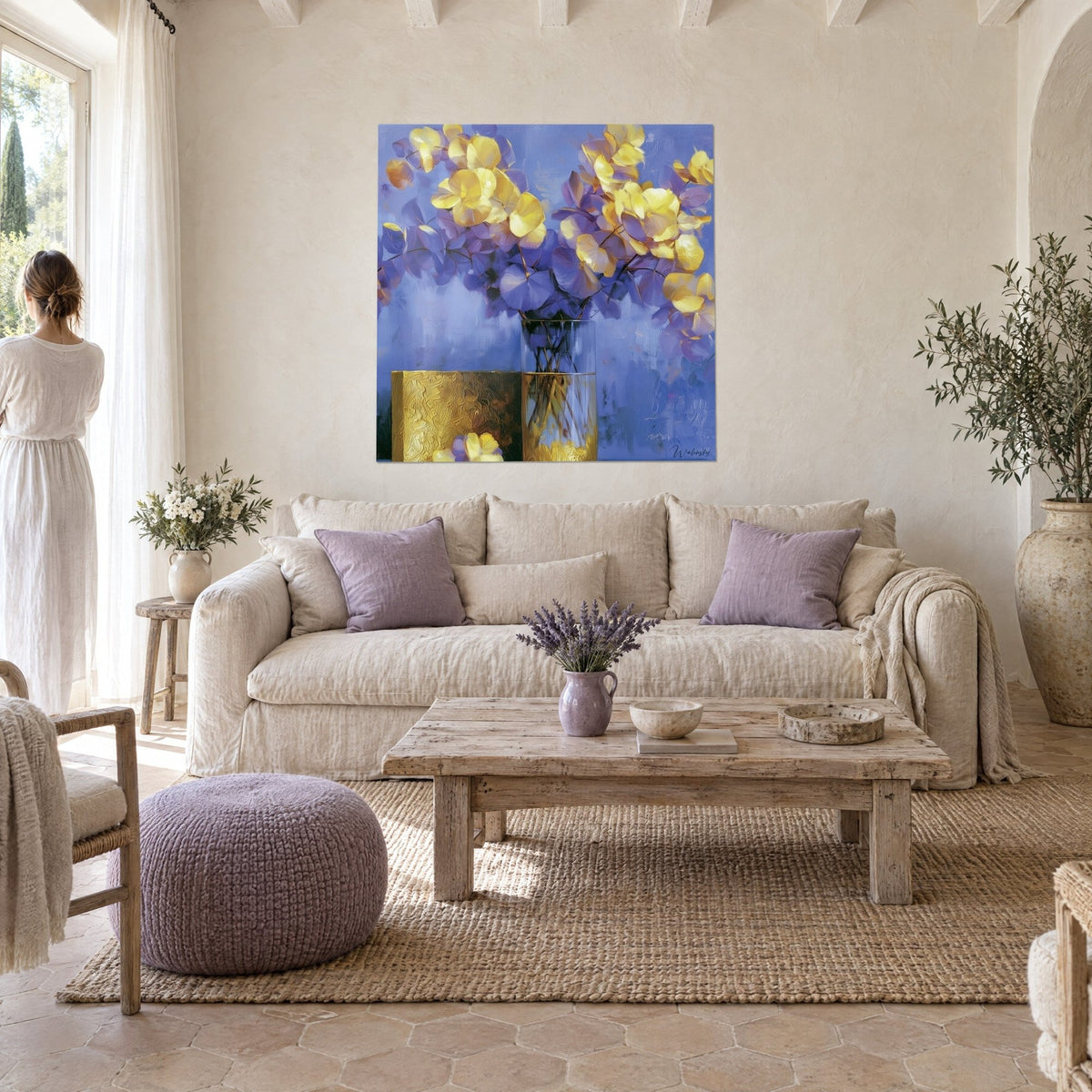 Gemälde mit goldenem und blauem Eukalyptusstrauß in einer Glasvase, gelbe Blütenblätter auf lavendelfarbenem Grund, über einem Sofa in einem hellen Wohnzimmer