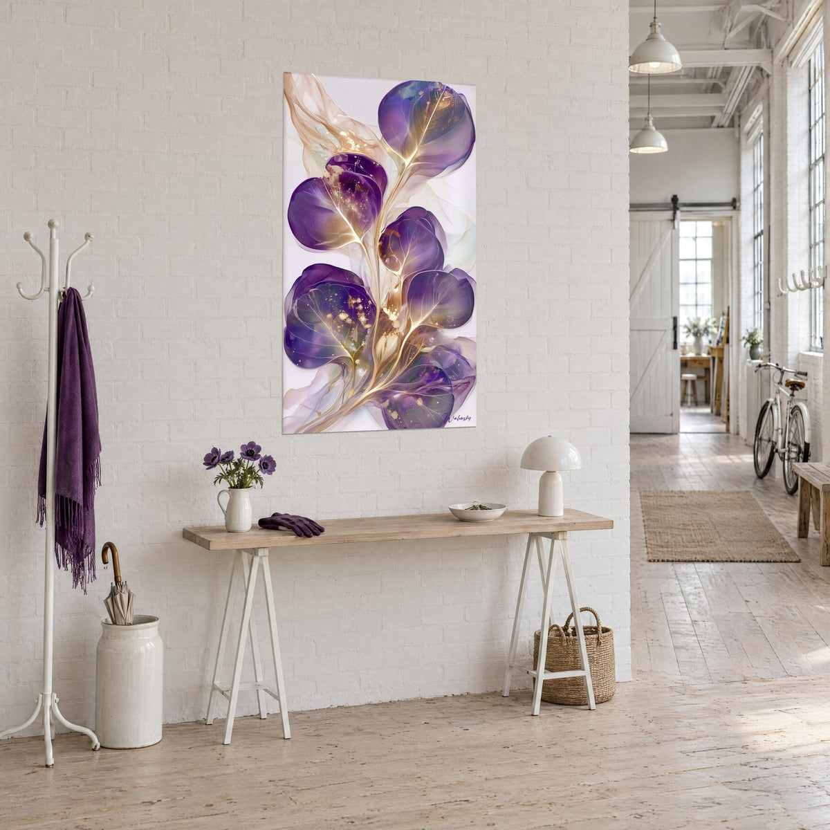 Schilderij tak met grote paarse bloemblaadjes en transparante gouden draden, naast een houten console in een kunstenaarsloft