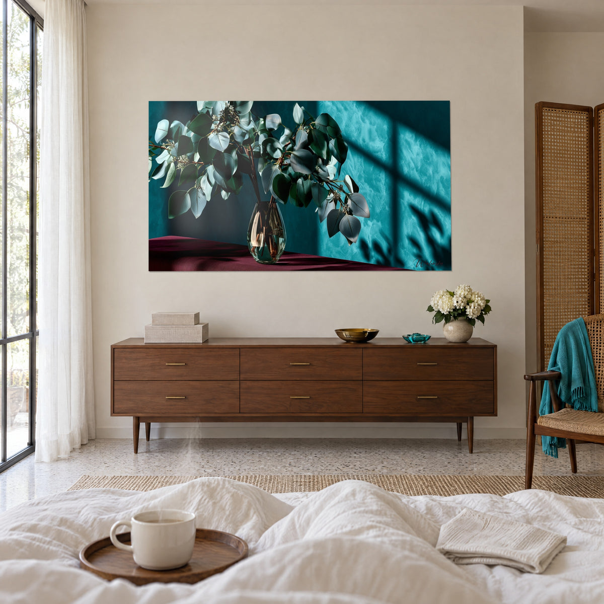 Cuadro follaje de eucalipto verde profundo y plateado, mantel burdeos, pared turquesa, colgado encima de una cama en un dormitorio luminoso