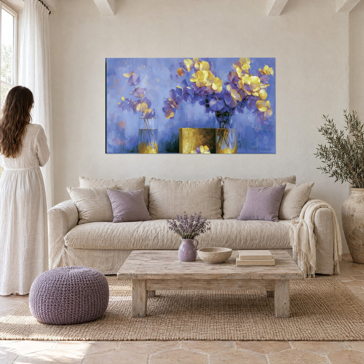 Quadro bouquet di eucalipto giallo e viola in due vasi di vetro, sfondo azzurro periwinkle, sopra un divano in un soggiorno luminoso