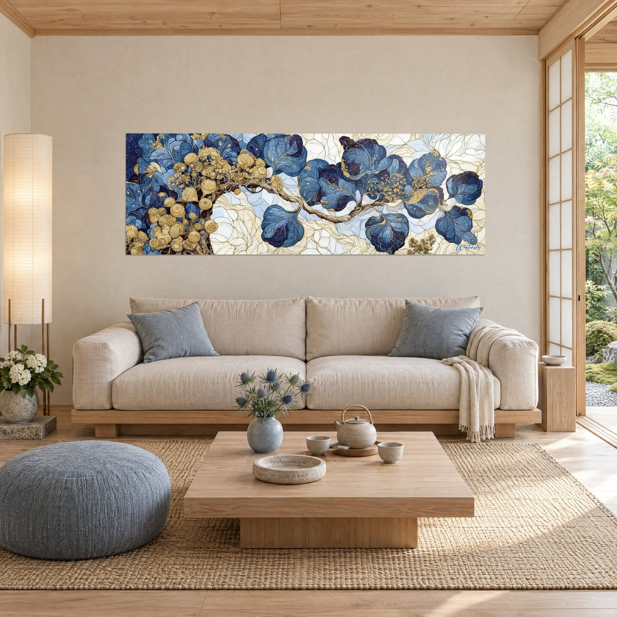 Tableau branche sinueuse aux feuilles bleu marine et baies dorées sur fond ivoire, au-dessus d'un canapé dans un salon lumineux