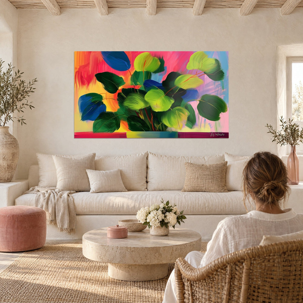 Schilderij tropisch bladwerk met grote zuurgroene en kobaltblauwe bladeren op een koraalroze achtergrond, boven een bank in een lichte woonkamer