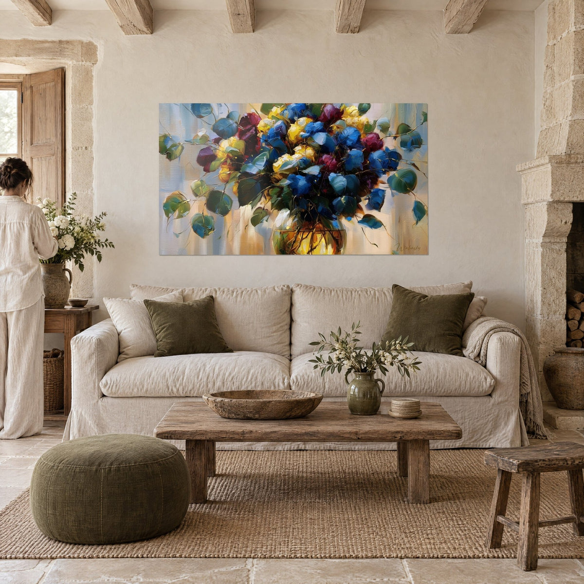 Tableau bouquet de roses bleu cobalt et jaune doré, feuilles d'eucalyptus vert-de-gris, au-dessus d'un canapé dans un salon lumineux