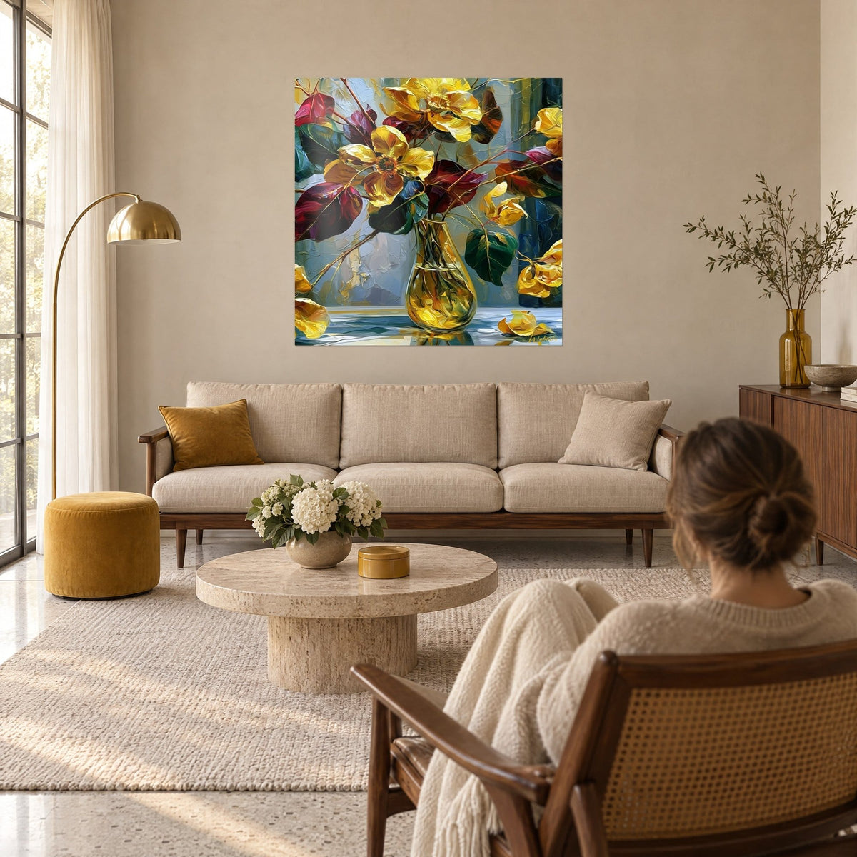 Cuadro ramo de flores doradas con hojas púrpura y verde abeto, jarrón de vidrio ámbar, encima de un sofá en un salón luminoso