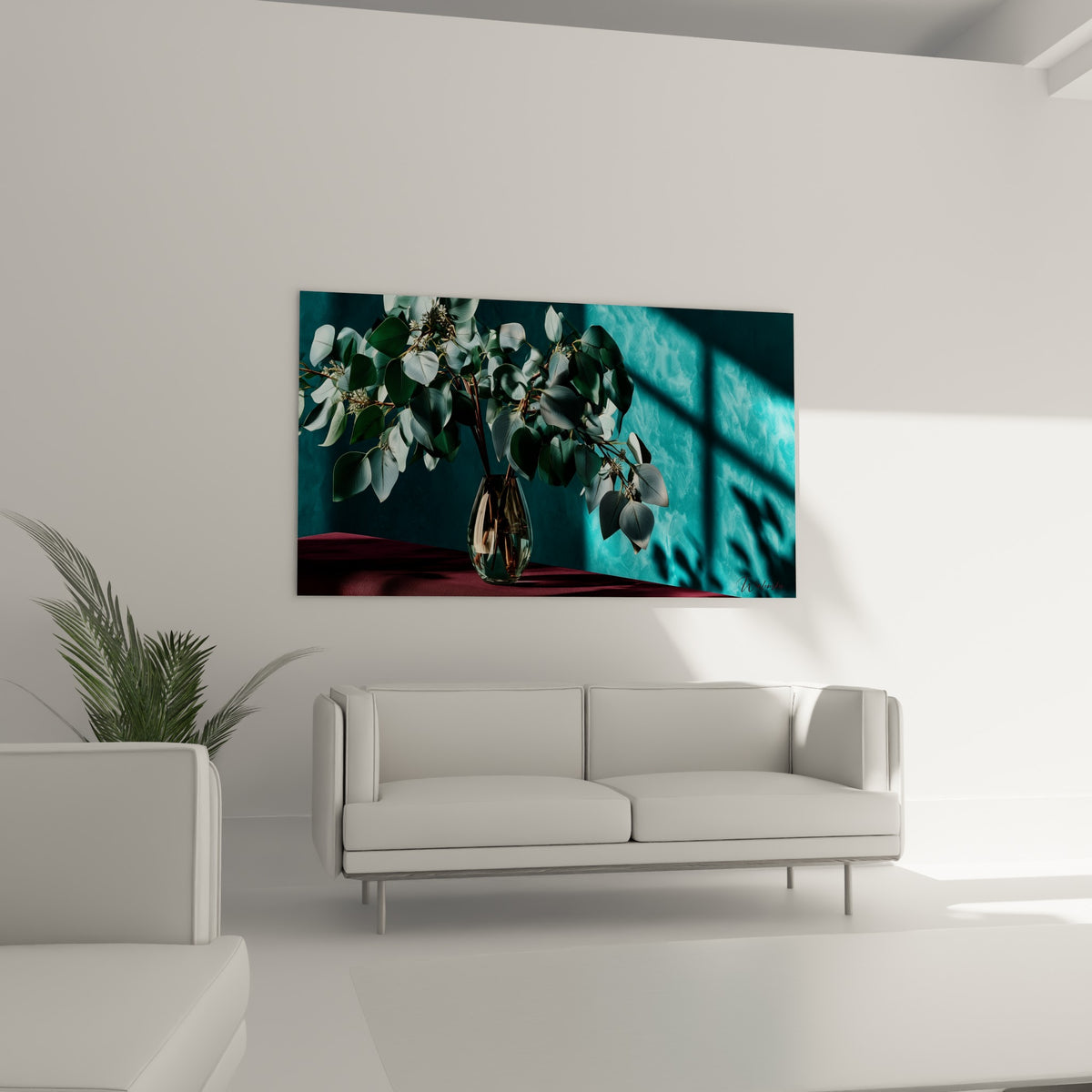 Vase d'eucalyptus vert-gris et reflets dorés accroché au-dessus d'un canapé dans un salon lumineux
