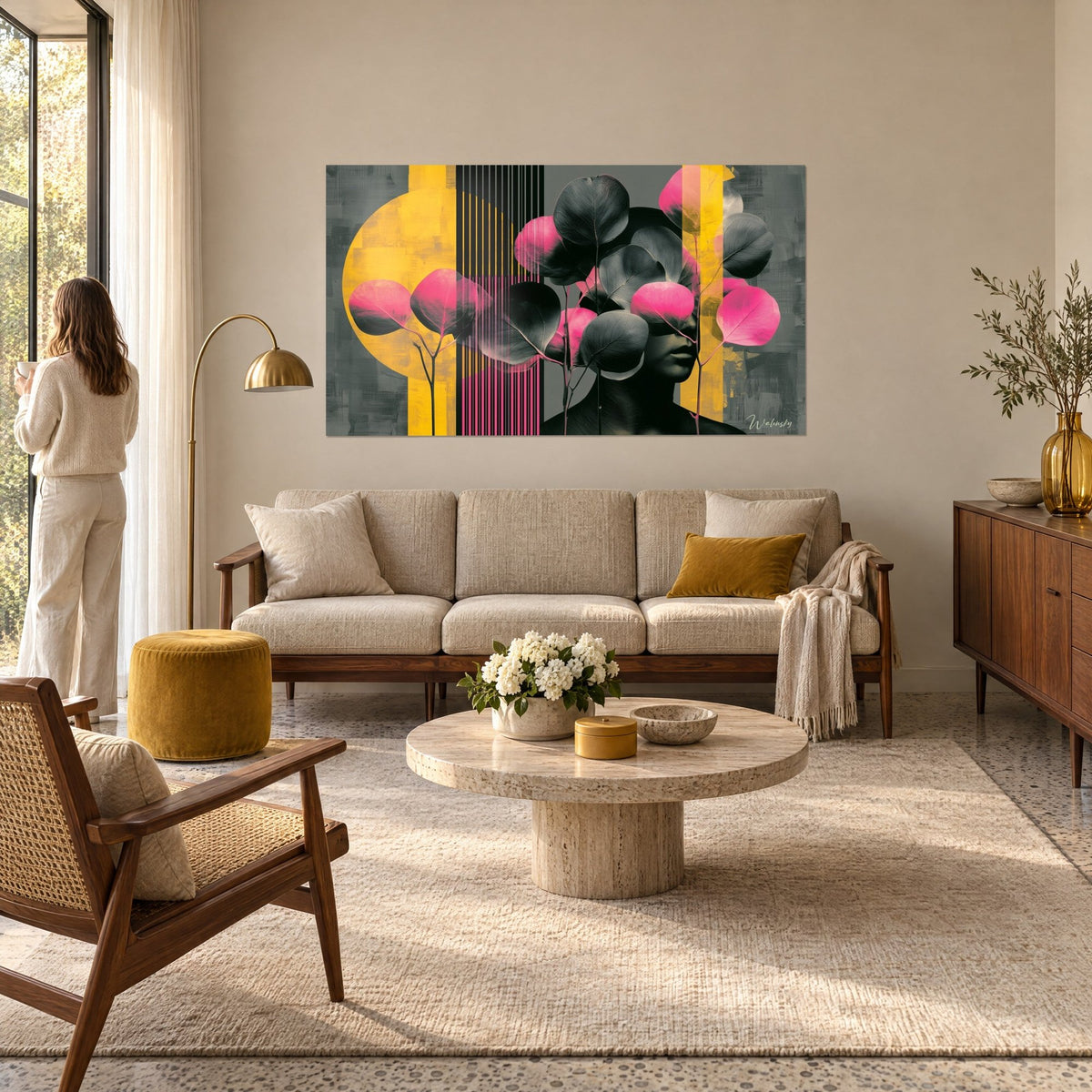 Schilderij ronde zwarte en roze eucalyptusbladeren die een gezicht verhullen, mosterdgele achtergrond, vrouw van achteren, boven een bank in een lichte woonkamer
