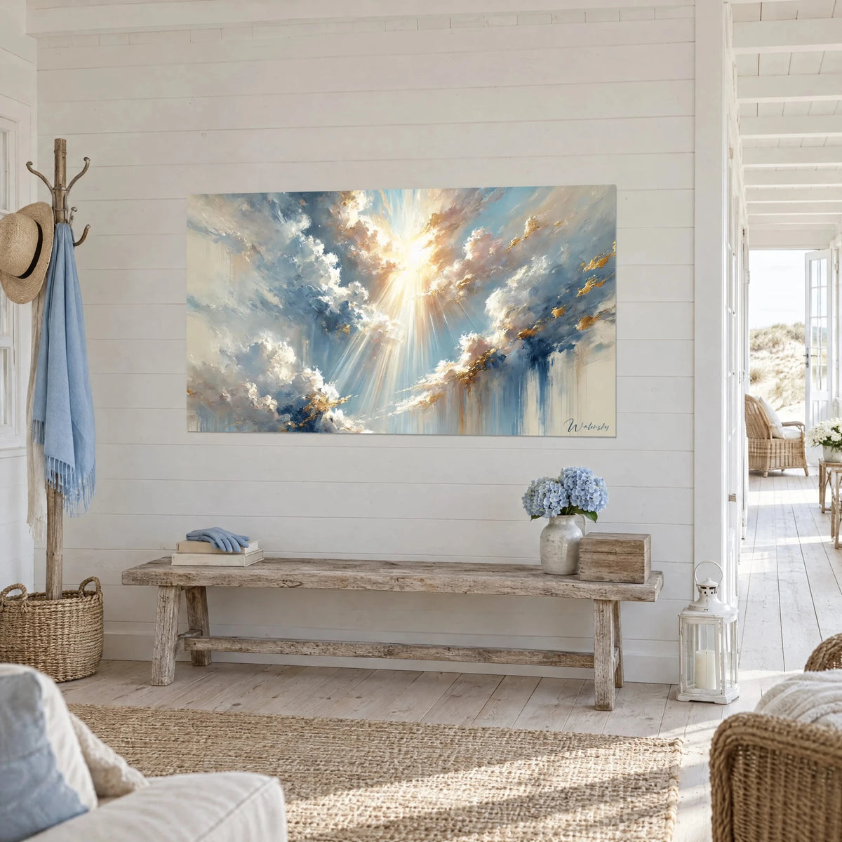 Wall art with light breaking through white cumulus clouds in blue and cream, golden glints, hung in a seaside entrance hall