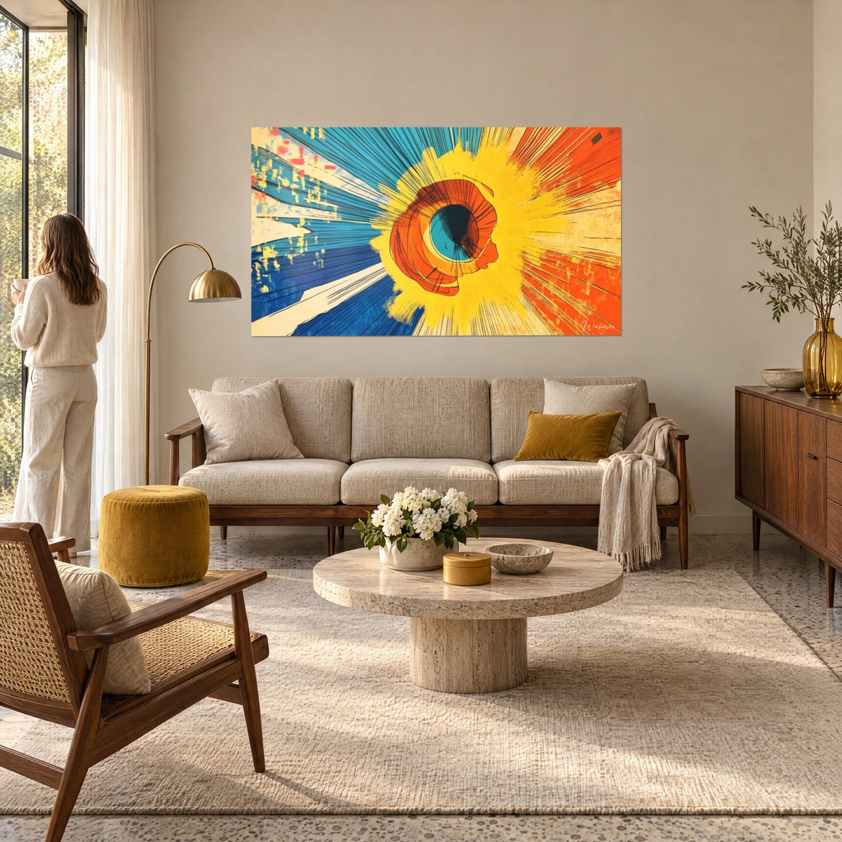 Tableau explosion solaire jaune éclatant sur rayons bleus et orange, femme de dos, au-dessus d'un canapé dans un salon lumineux