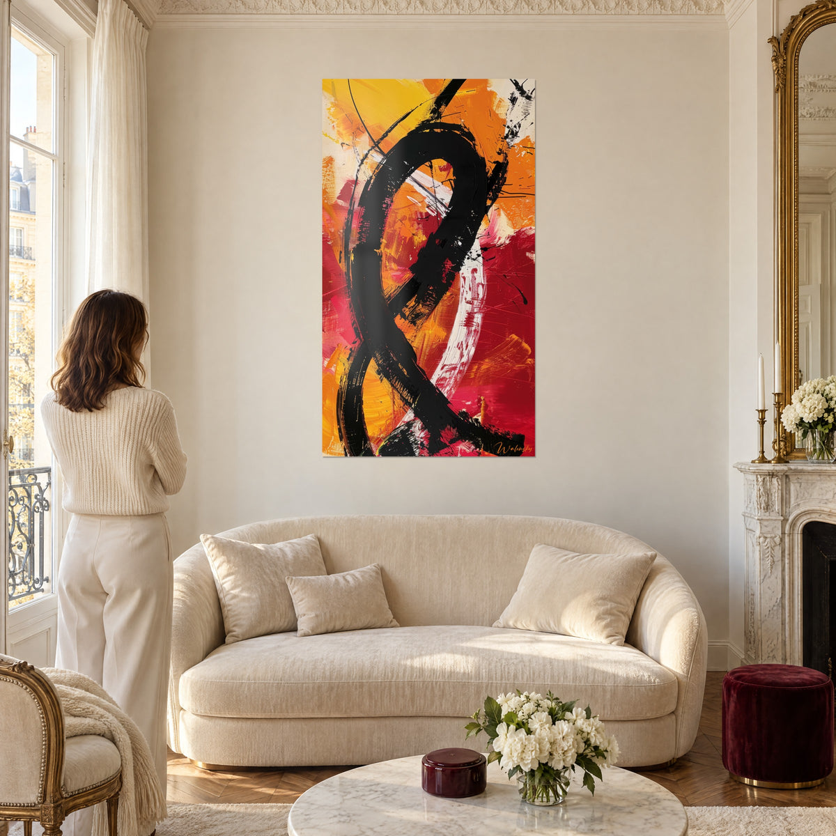 Tableau boucle de peinture noire sur fond orange et rouge vif, au-dessus d'un canapé dans un salon lumineux