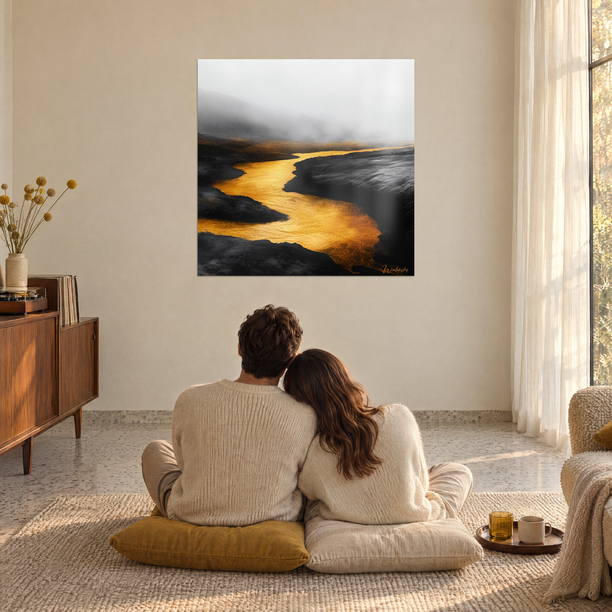 Tableau paysage de lande noire fendu par un fleuve d'or, brume blanche en haut, couple enlacé de dos sur coussins moutarde dans un séjour