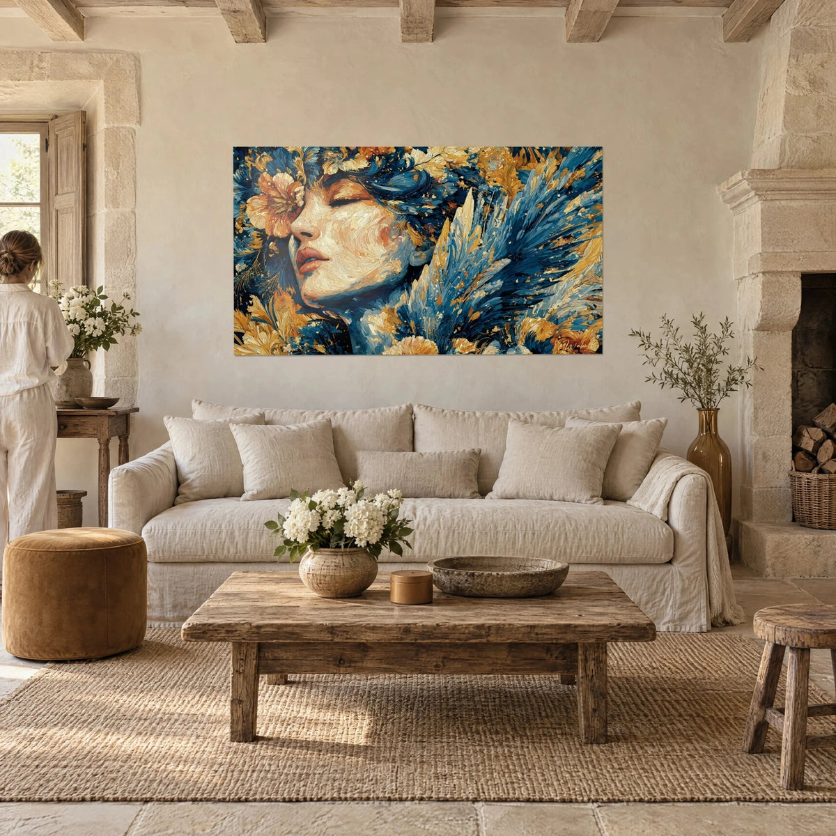 Cuadro rostro femenino con párpados cerrados rodeado de plumas azul cobalto y flores ocre, sobre un sofá en un salón luminoso