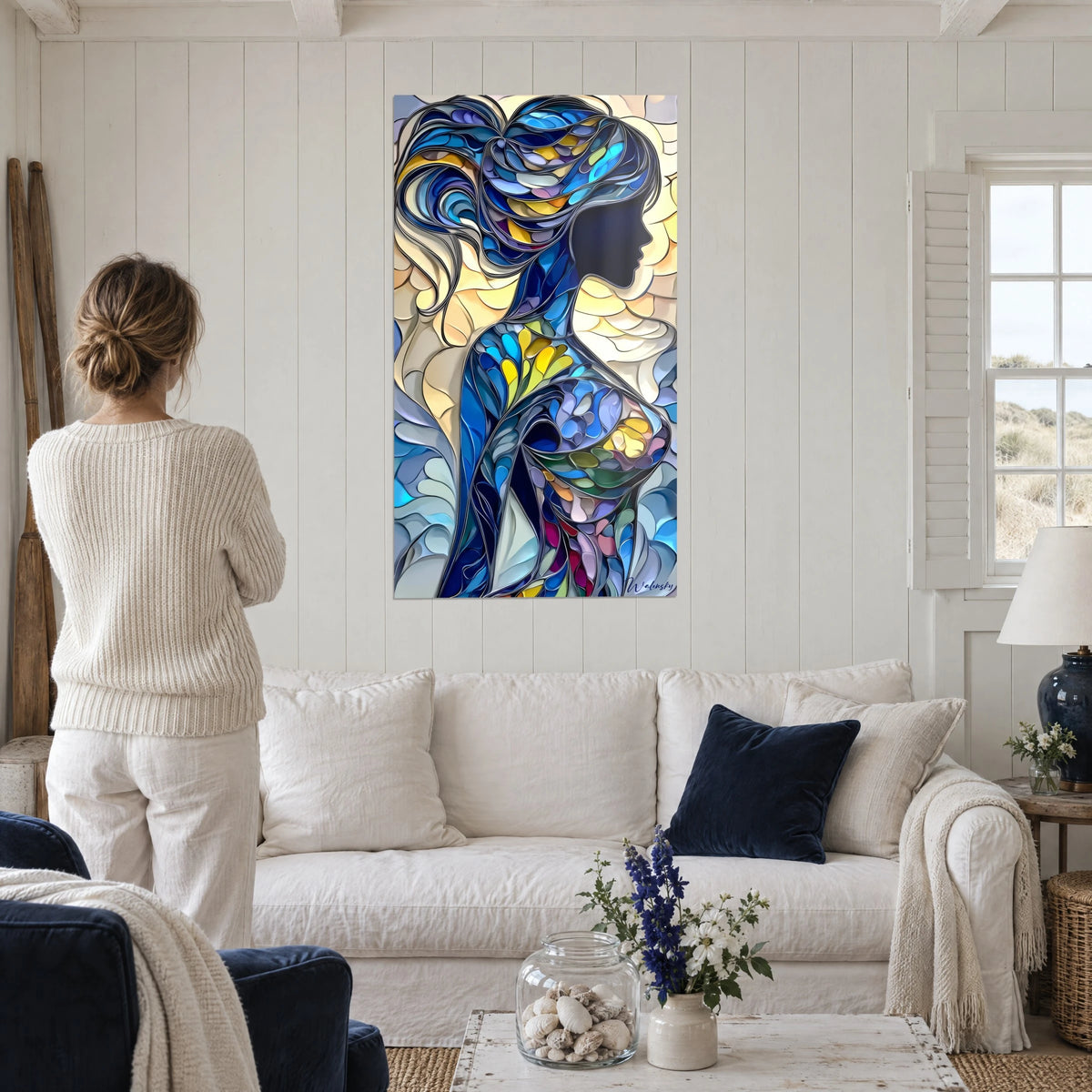 Quadro silhouette femminile con capelli color zaffiro, blu cobalto e giallo pallido, sopra un divano in un soggiorno luminoso