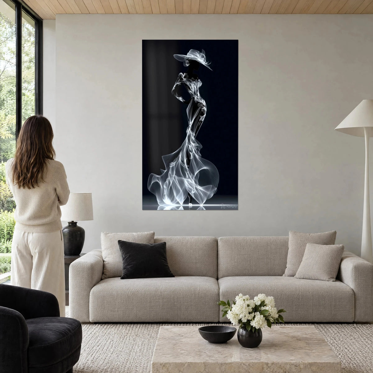 Tableau silhouette élégante en robe de voile blanc sur fond noir profond, large chapeau, au-dessus d'un canapé dans un salon lumineux