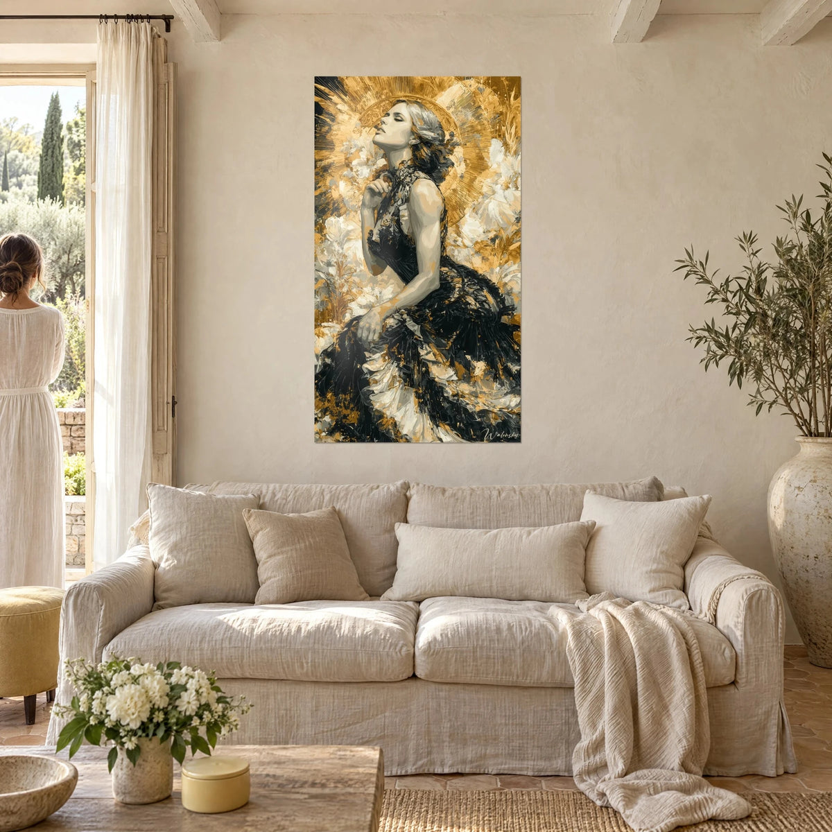 Wall art woman with face lifted under a golden halo, black feathered dress, ivory flowers, above a sofa in a bright living room