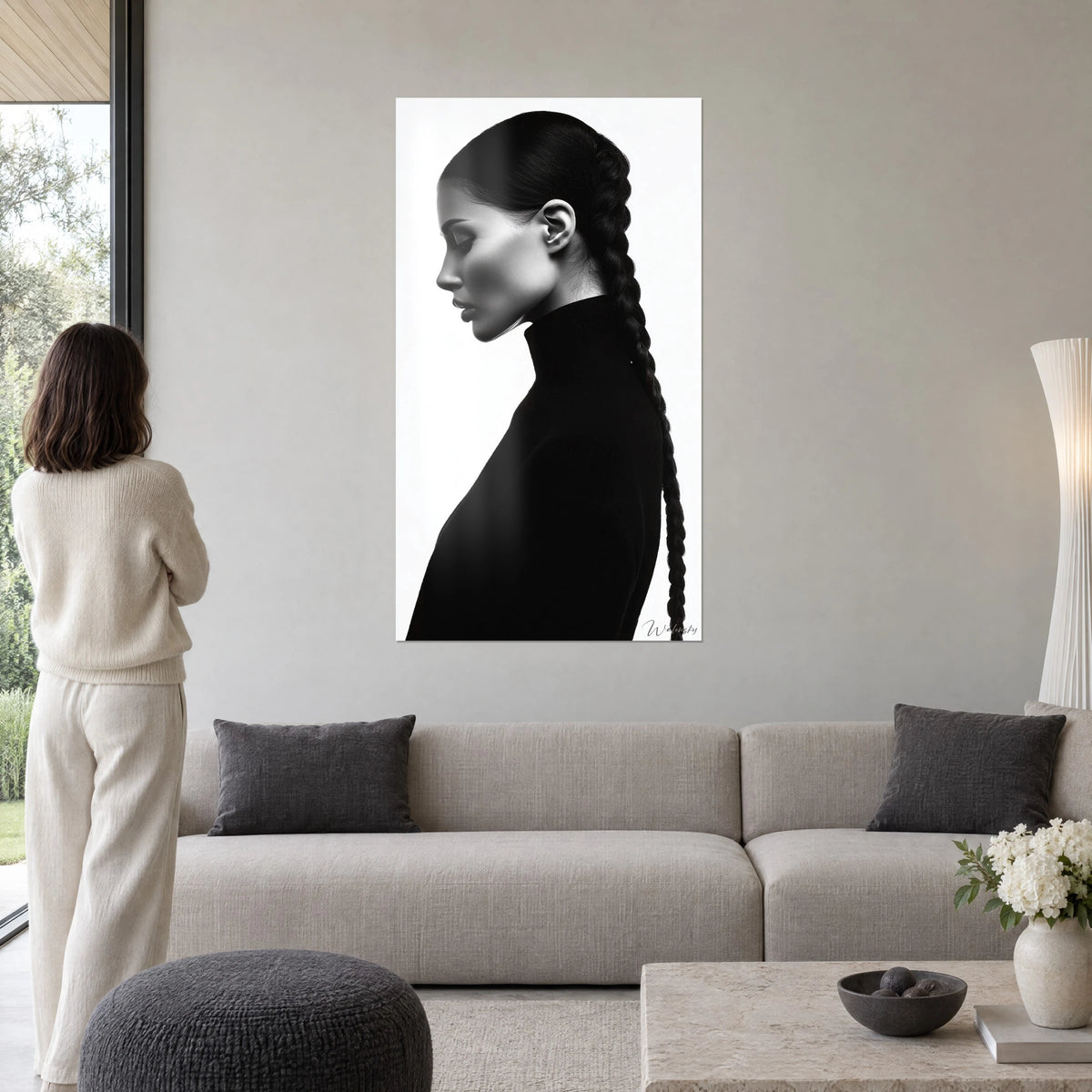 Schilderij vrouw in profiel met lange zwarte vlecht, coltrui op witte achtergrond, boven een bank in een lichte woonkamer