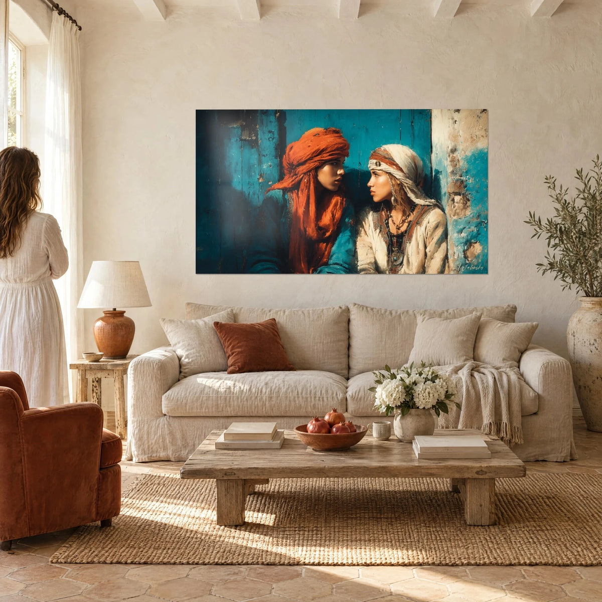 Tableau deux jeunes femmes en confidence, turban orange et voile crème sur porte turquoise, au-dessus d'un canapé dans un salon lumineux