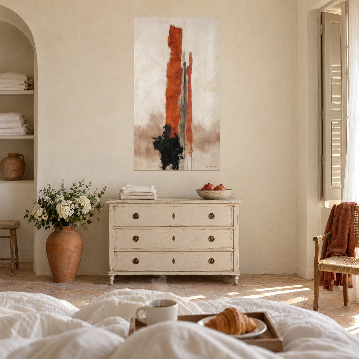 Wall art copper-orange stelae and black line on cream veil, brown wash at the bottom, a woman seen from behind above a bed in a bright bedroom