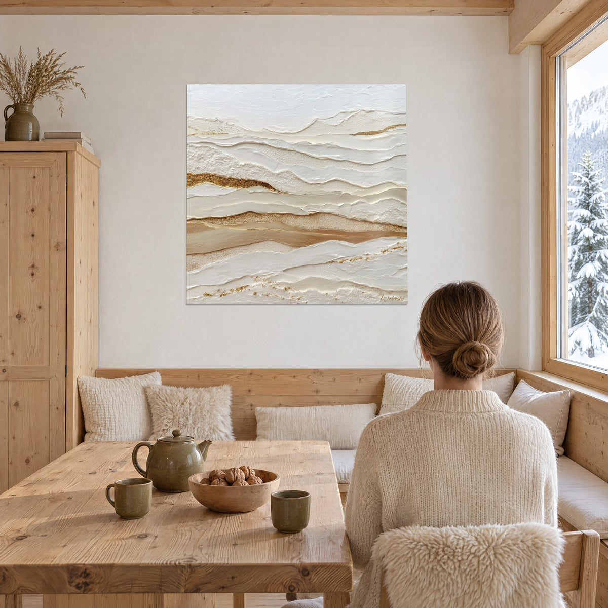 Schilderij met gelaagd reliëf in parelmoerwit en honingtinten, gouden glans, vrouw met de rug naar de kijker aan een houten tafel, besneeuwde chalet