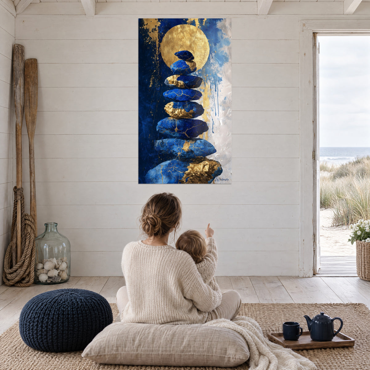 Schilderij beeldhouwwerk van azuurblauwe stenen met gouden craquelé, gouden hemellichaam en krijtwitte achtergrond, lichte woonkamer met uitzicht op de duin