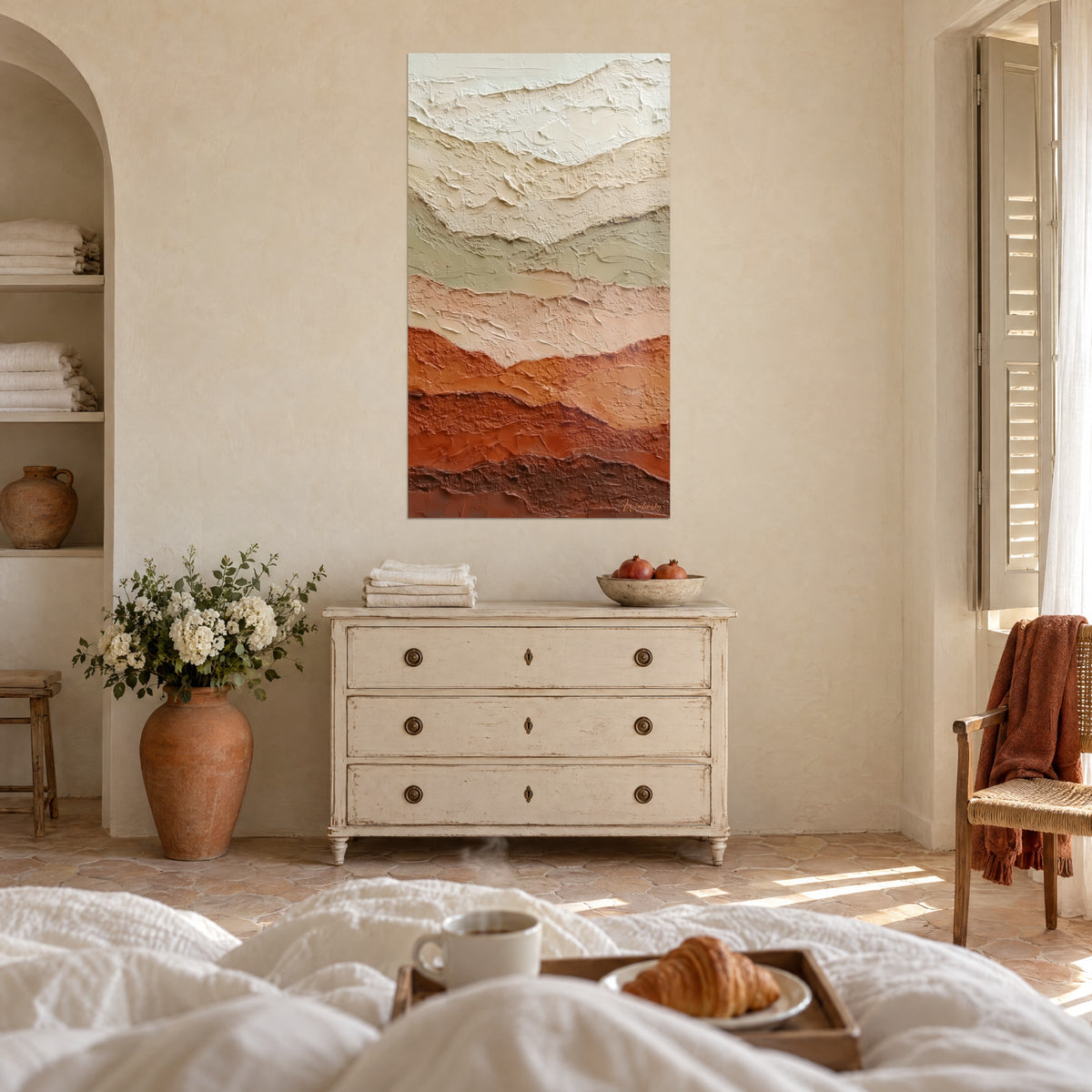 Wall art with thick-relief ridges in orange ochre and rosy beige, hung above a bed in a light bedroom