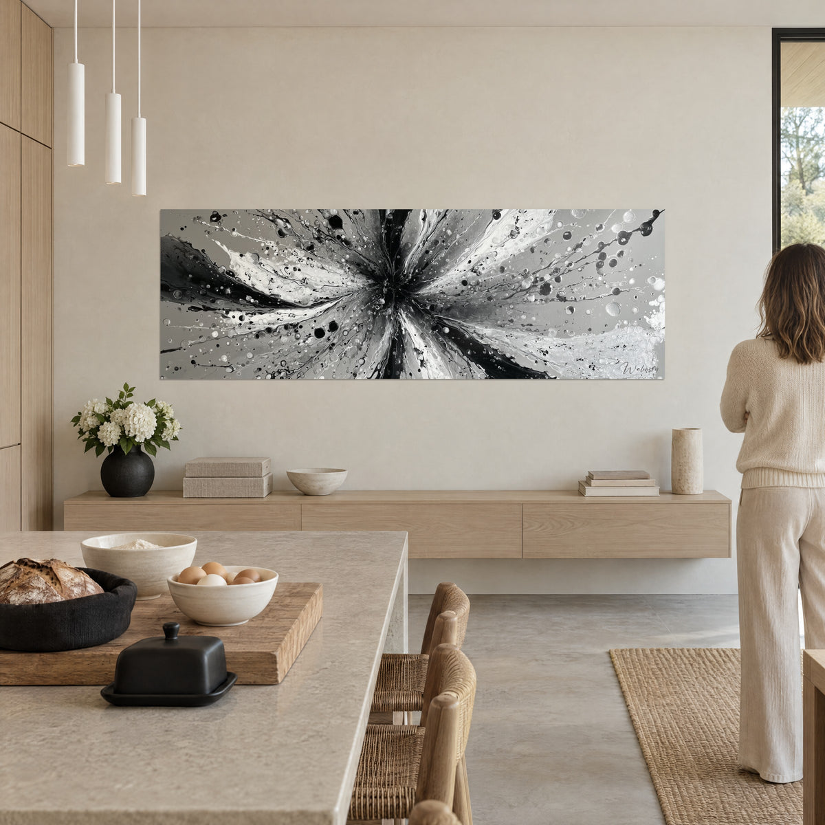 Schilderij ster van zwart-witte inktblaadjes, verspreide grijze druppels, tegenover een vrouw van achteren in een crèmekleurige trui