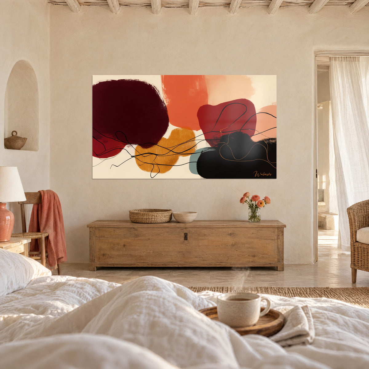 Cuadro de pintura abstracta en curvas ocre, burdeos y rosa pálido, sábanas blancas y una taza sobre la cama en un dormitorio luminoso