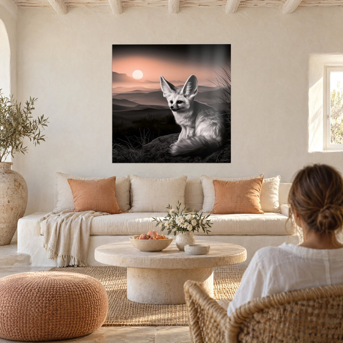 Gemälde Wüstenfuchs mit großen Ohren auf einem Felsen sitzend, lachsrosa Himmel und graue Dünen, über einem Sofa in einem hellen Wohnzimmer