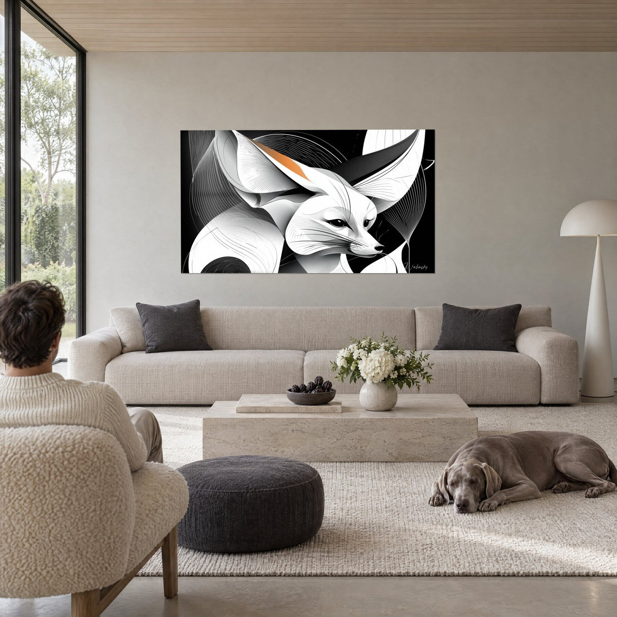 Wall art desert fox with oversized ears, black and white, orange accent, above a sofa in a bright living room