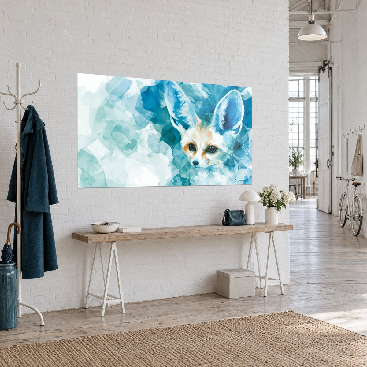 Cuadro fennec en acuarela, mirada oscura y pelaje arena rodeados de manchas azur y menta, en una pared blanca de entrada