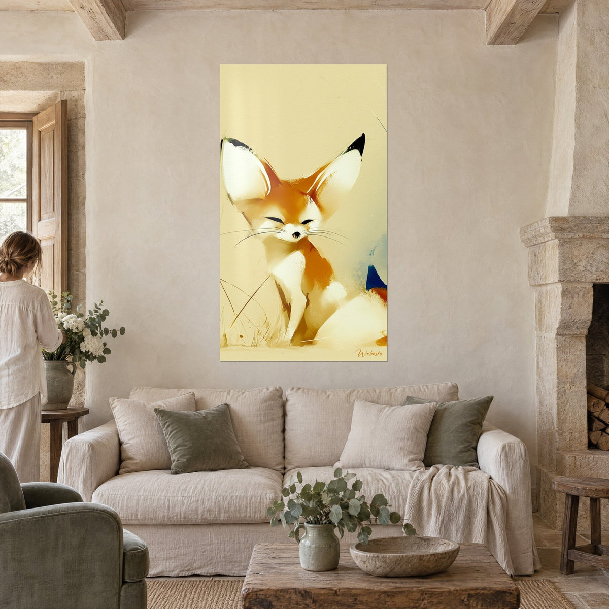 Wall art desert fox with huge cream-white and orange ears, eyes closed, woman seen from behind, above a sofa in a bright living room