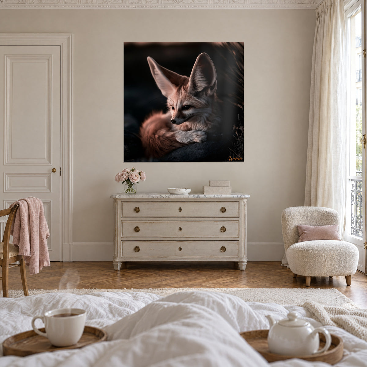 Cuadro de fenec de mirada apacible, grandes orejas rosadas y patas blancas cruzadas, encima de una cama en un dormitorio claro