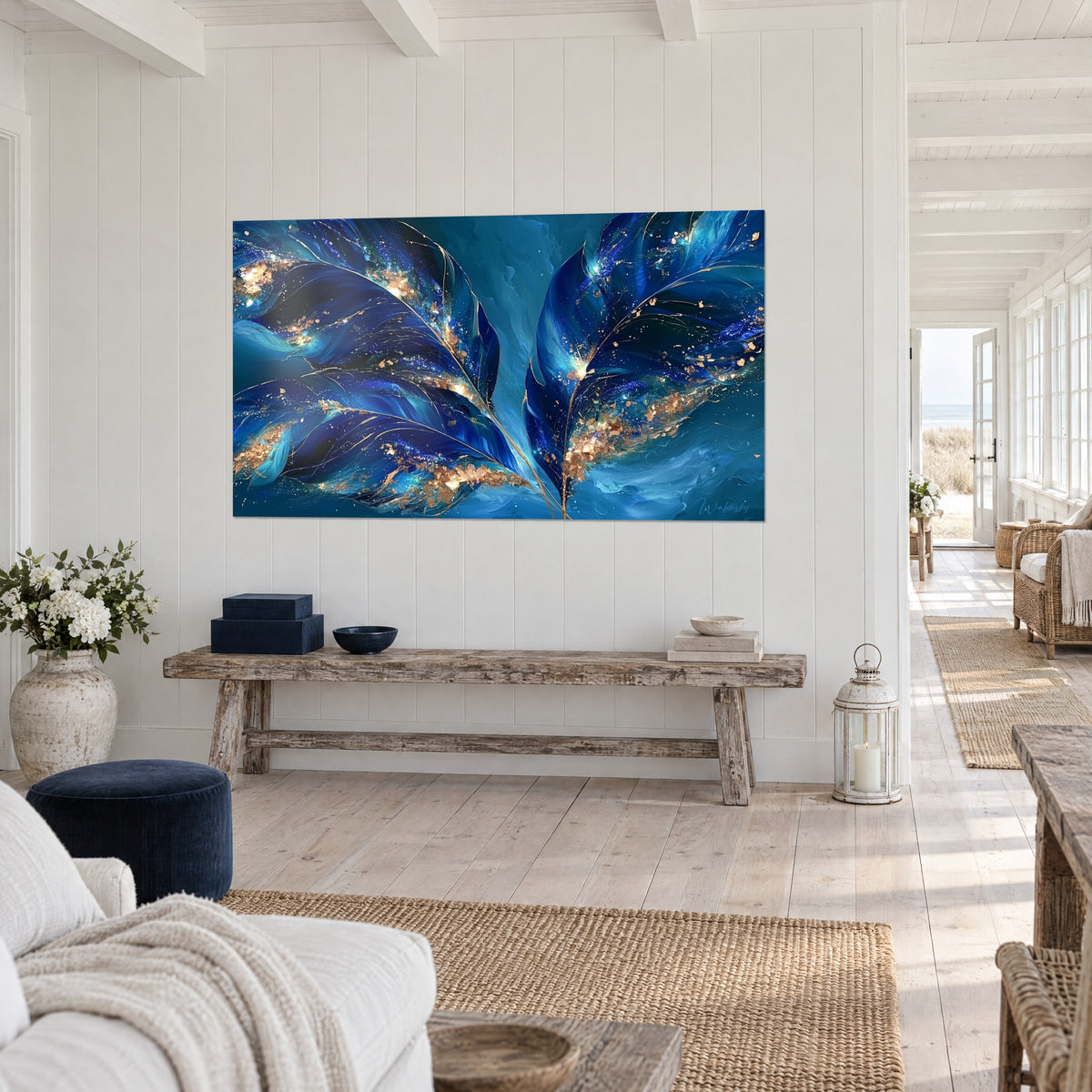 Tableau plumes géantes indigo parsemées de paillettes cuivrées sur fond turquoise, accroché au-dessus d'un banc rustique, maison de bord de mer