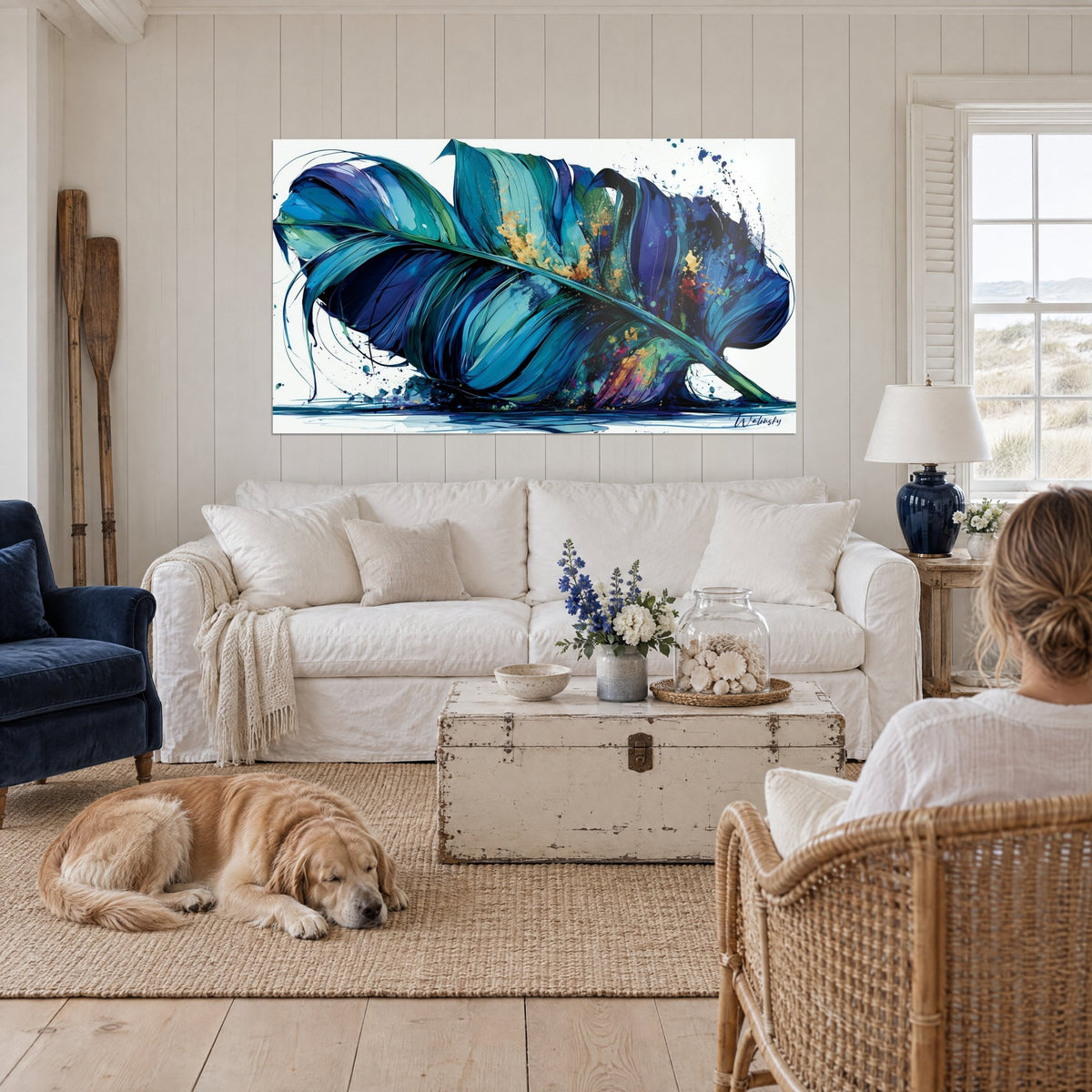 Cuadro hoja de plátano en azul cobalto y turquesa, salpicaduras doradas, golden retriever tumbado frente a un sofá en un salón luminoso