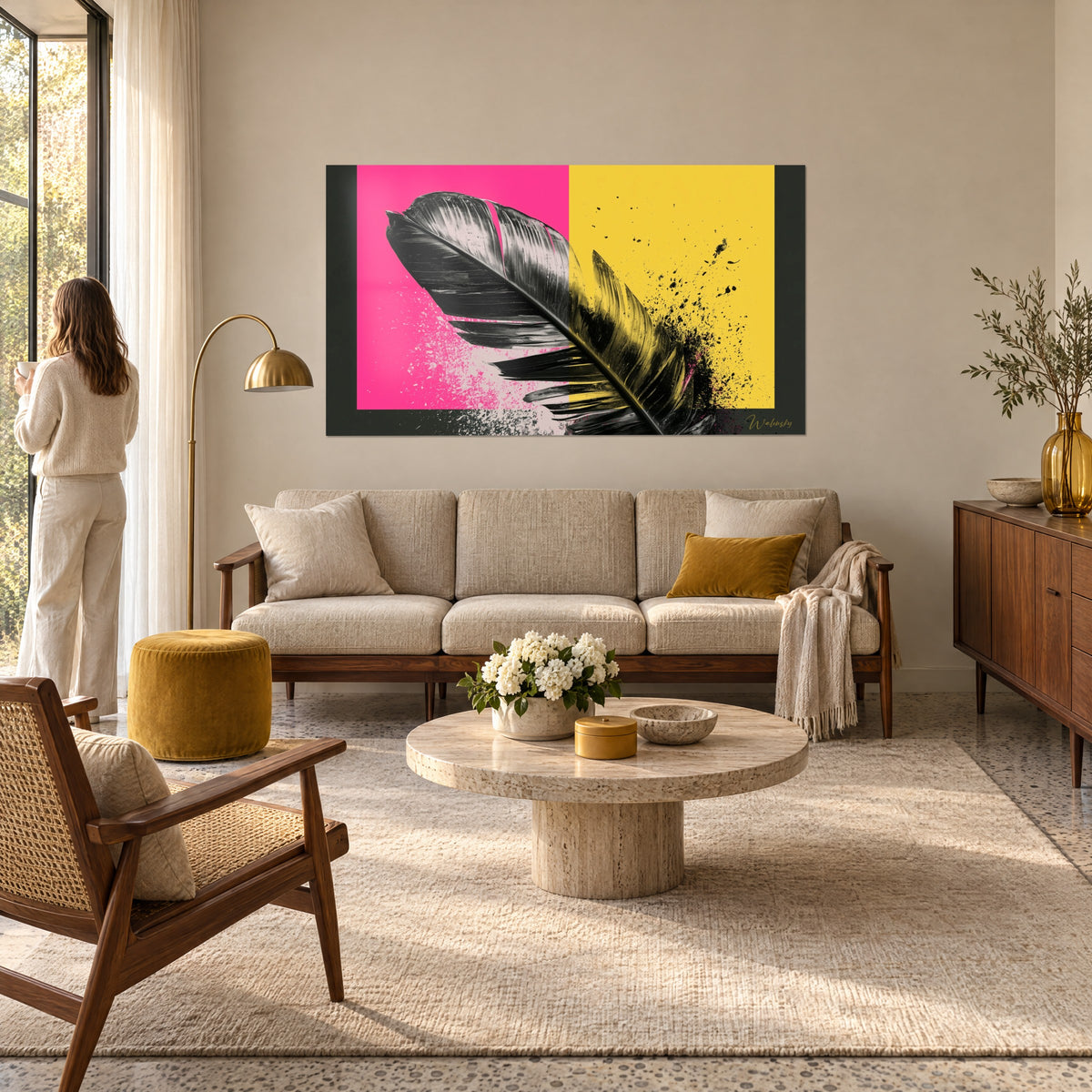 Tableau plume noire aux reflets argentés sur fond rose vif et jaune, éclaboussures de peinture, au-dessus d'un canapé dans un salon lumineux