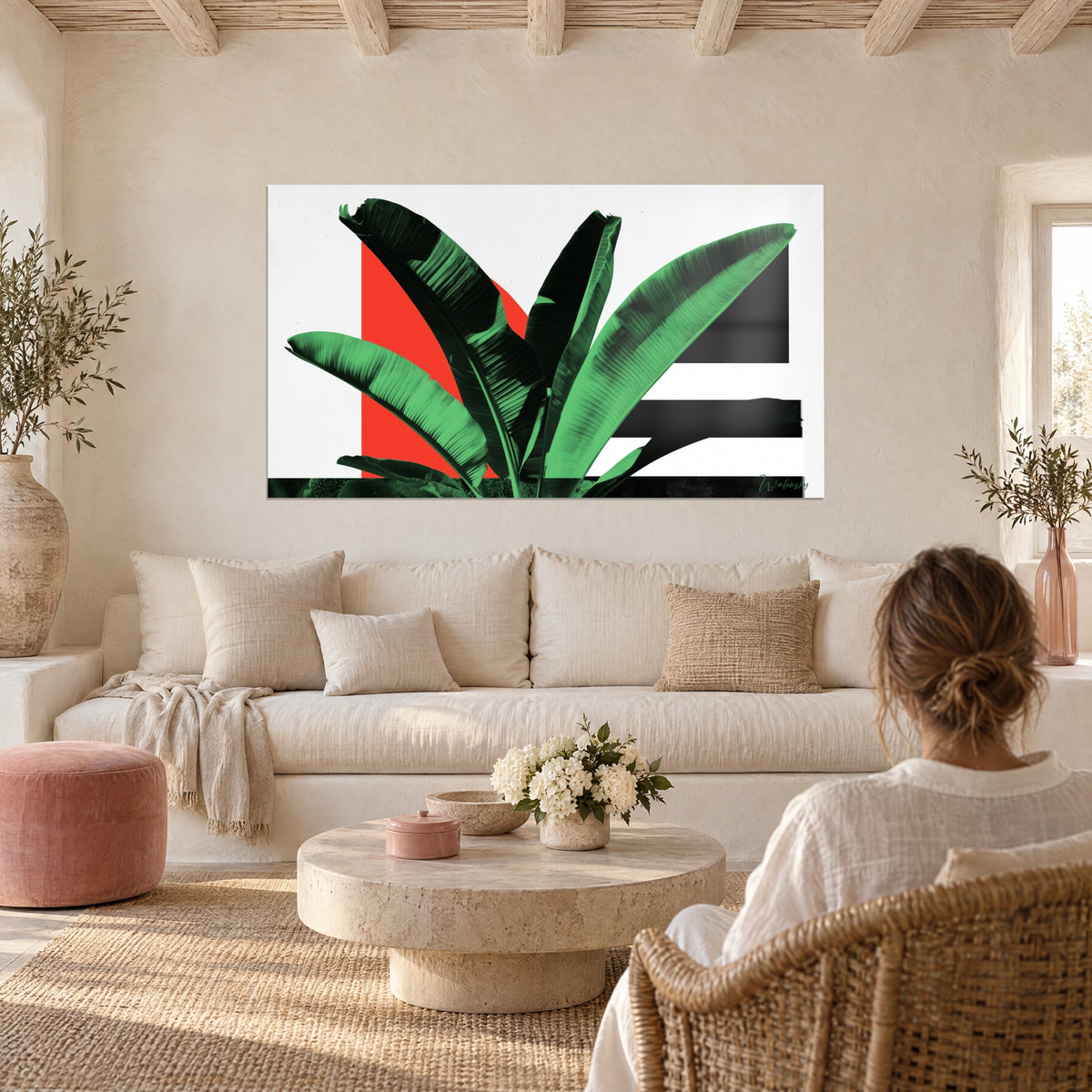 Tableau bananier aux larges palmes vert émeraude sur demi-disque rouge vif, au-dessus d'un canapé dans un salon lumineux