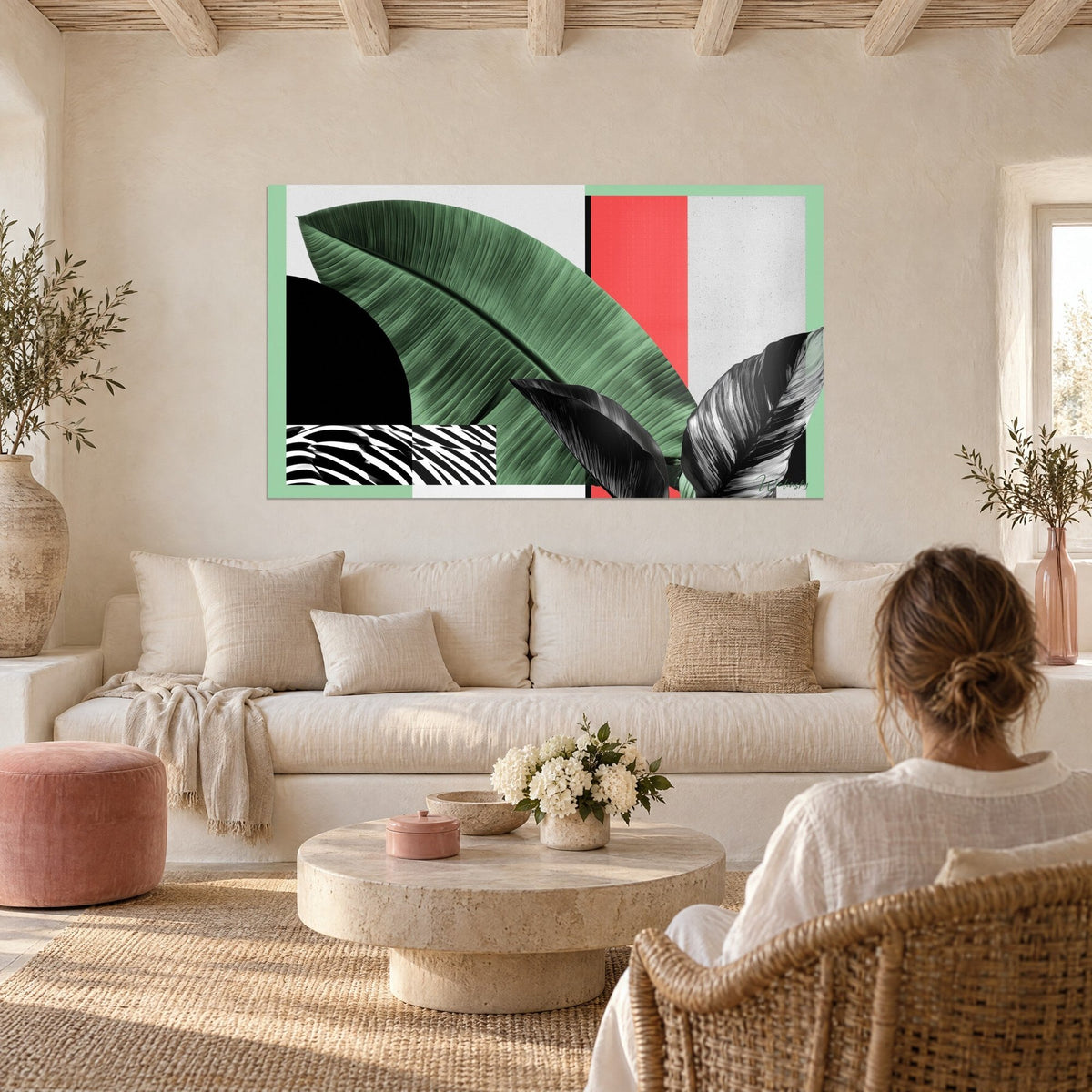 Gemälde grünes Bananenblatt in Salbeigrün, korallenfarbenes Band und schwarzer Halbkreis, über einem Sofa in einem hellen Wohnzimmer