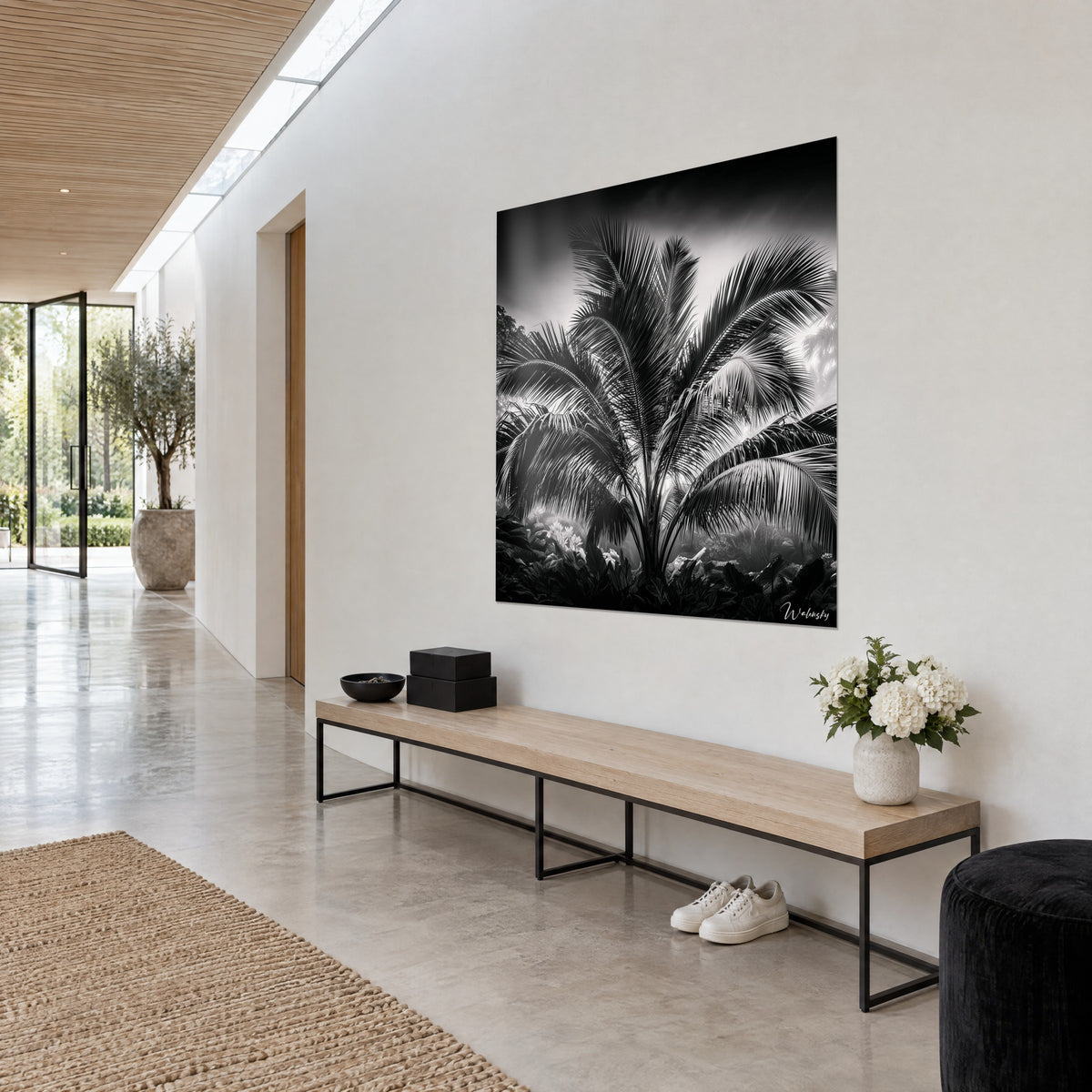 Wall art coconut palm with black and white fronds, dense foliage, three-quarter view on a beige wall in a bright hallway