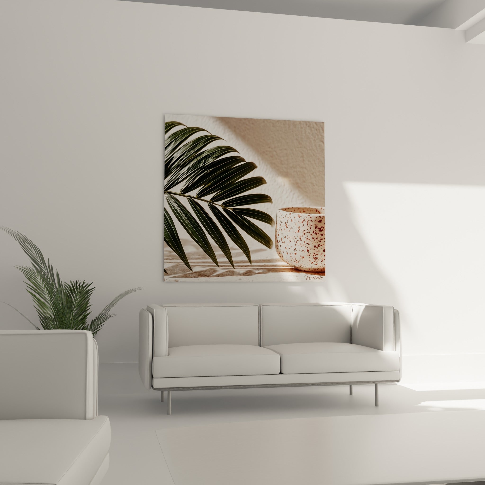 Feuillage vert sombre et céramique mouchetée disposés au-dessus d'un canapé dans un salon lumineux