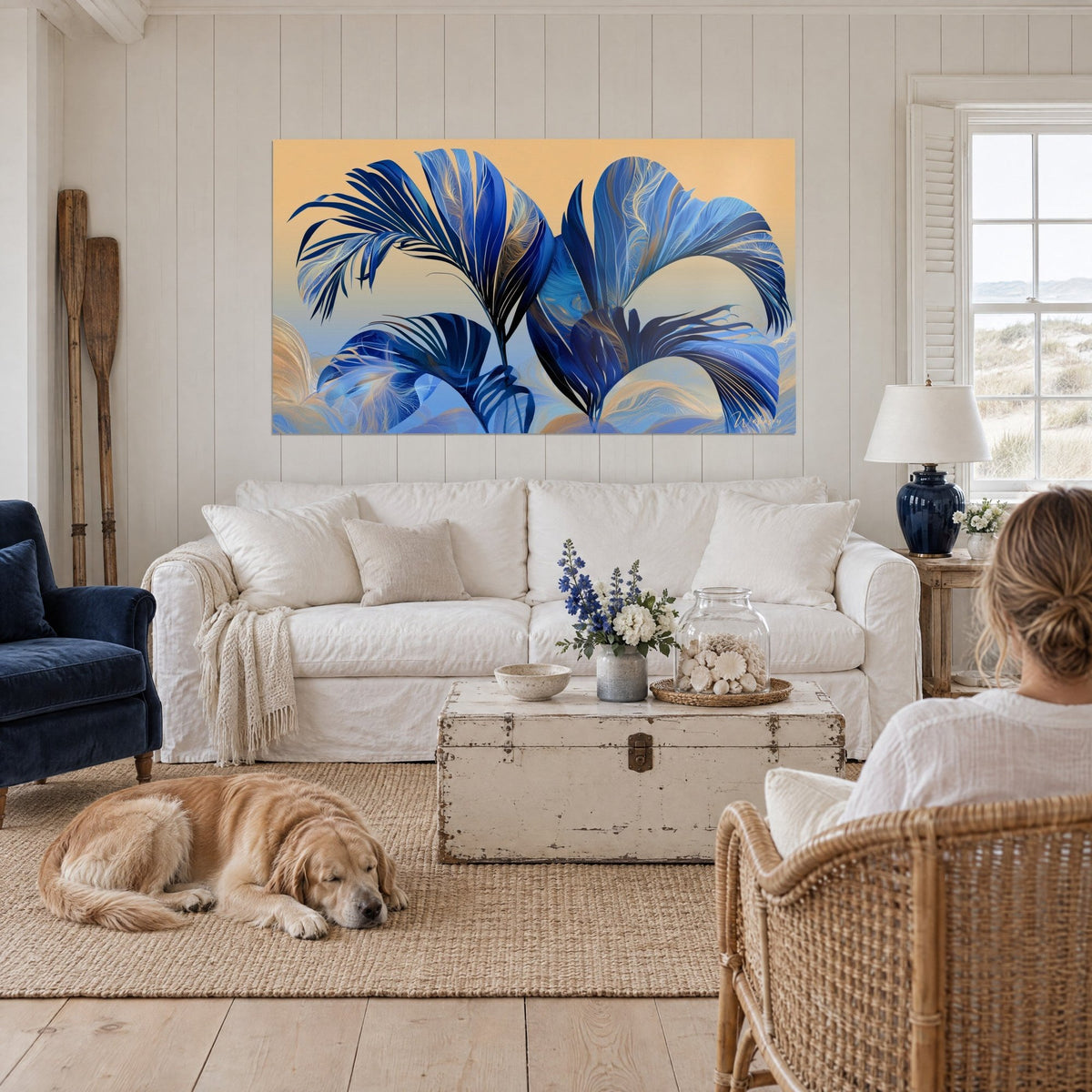 Gemälde Palmenblätter indigoblau mit Goldadern auf pfirsichfarbenem Grund, über einem Sofa in einem hellen Wohnzimmer