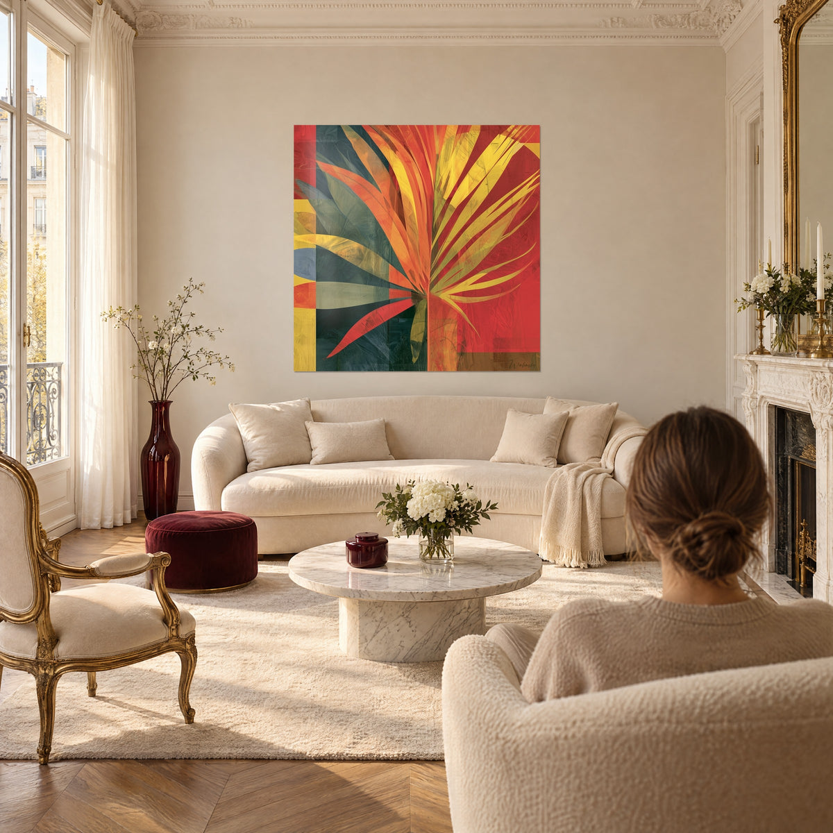 Wall art flaming palm with orange and yellow fronds on a bright red background, above a sofa in a light-filled living room