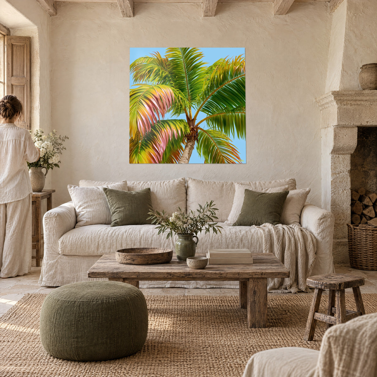Palm tree wall art with green and pink fronds under a blue sky, two people seen from behind, above a sofa in a bright living room