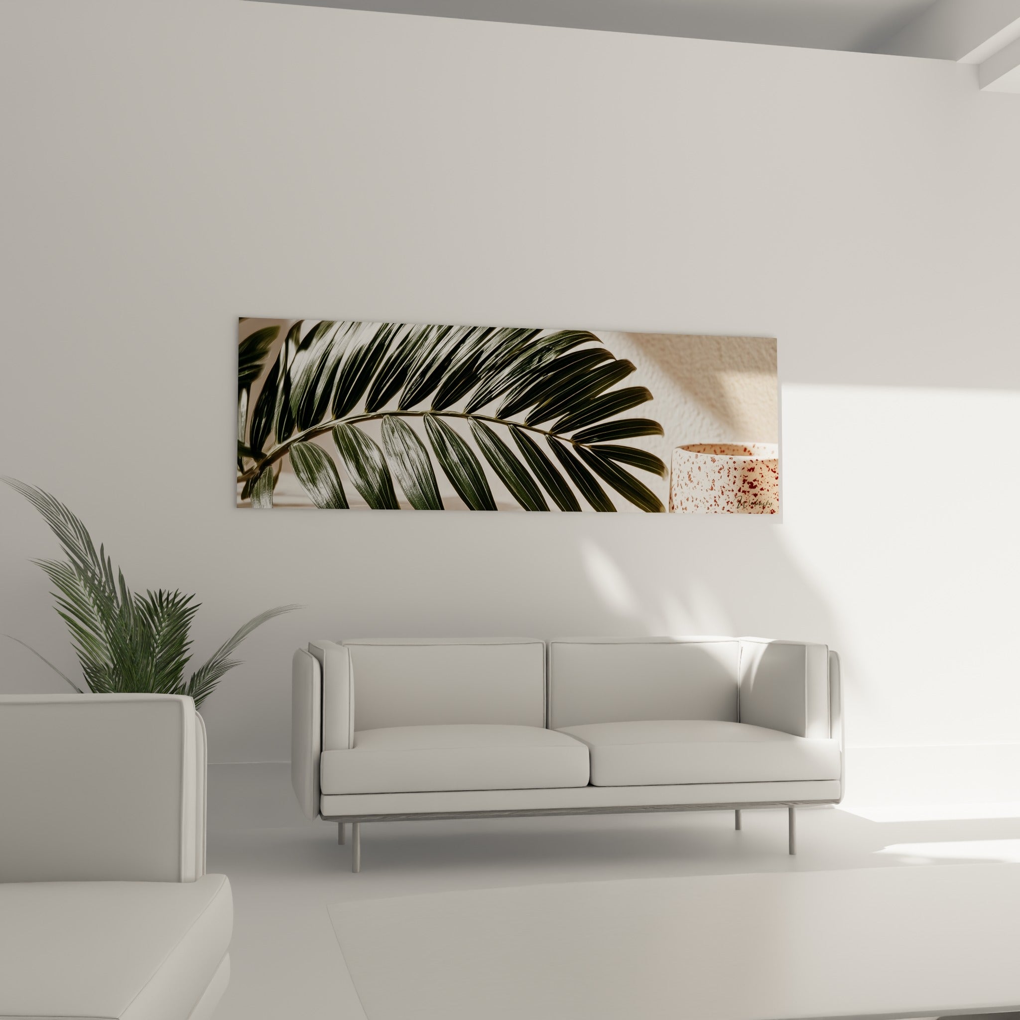 Folioles vertes et fond beige d'une feuille de palmier accrochées au-dessus d'un canapé dans un salon lumineux