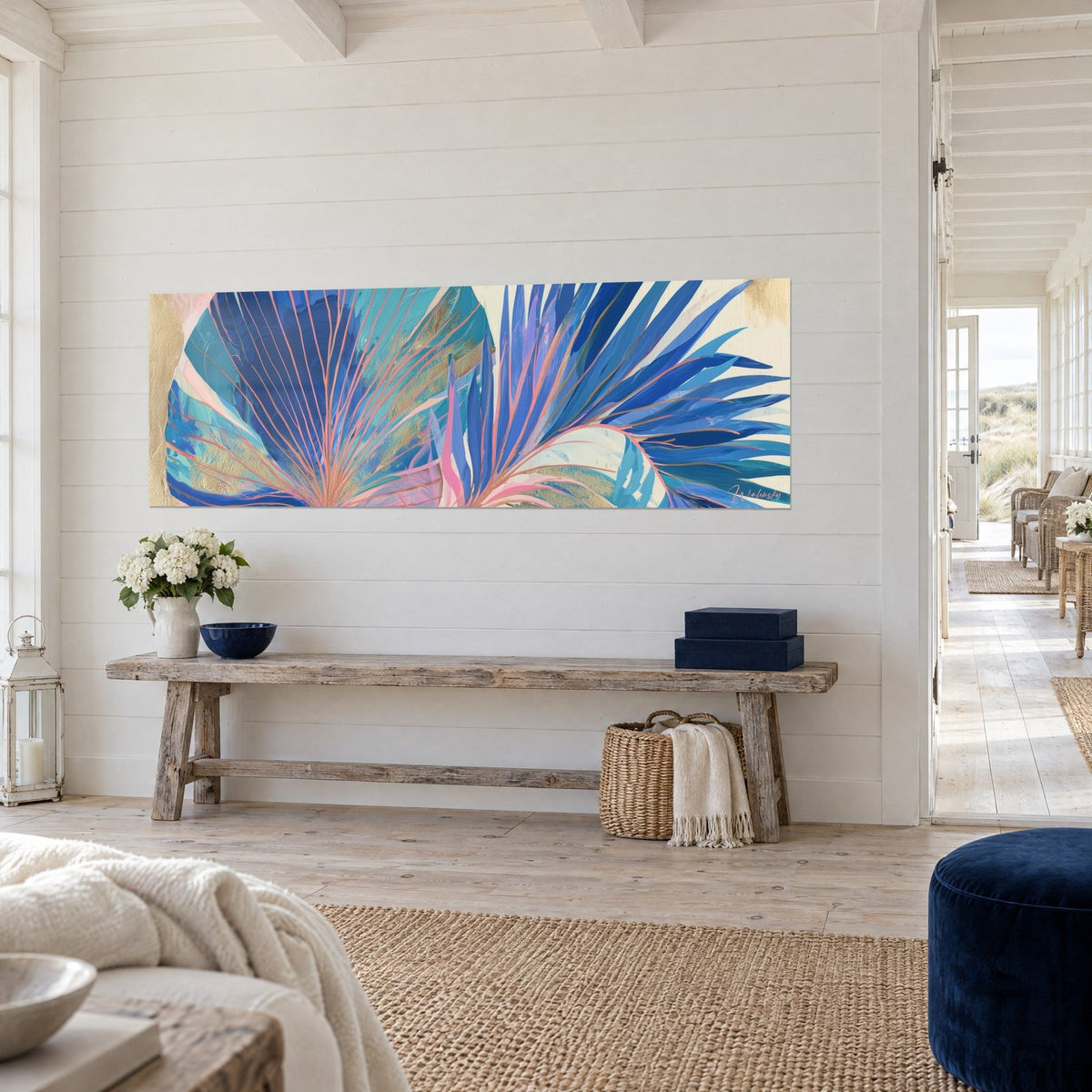 Wall art cobalt blue palm leaf, pink lines and gold dust on a cream background, white plank wall, rustic wooden bench
