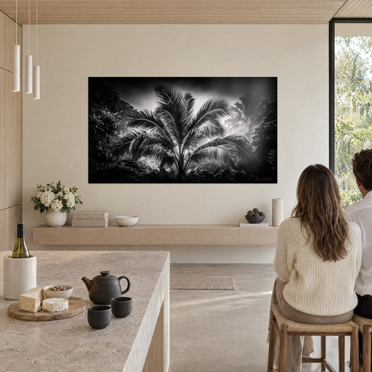 Tableau jungle en noir et blanc, éventail de palmes brillantes et fougères sombres, mur beige et grande baie vitrée, salle à manger