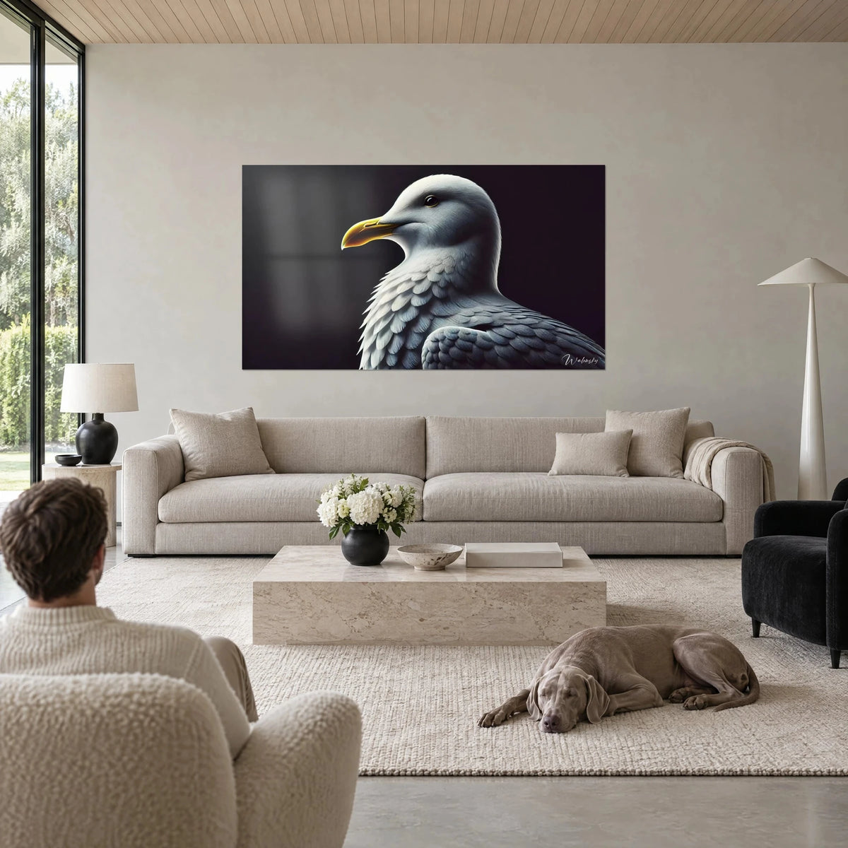 Quadro gabbiano di profilo con becco giallo vivo e piumaggio grigio perla su fondo nero, sopra un divano in un soggiorno luminoso