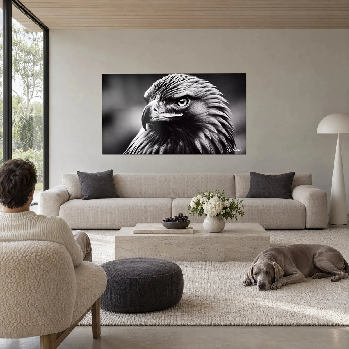 Gemälde Steinadler mit durchdringendem Blick, graue und schwarze Federn, gebogener Schnabel, über einem Sofa in einem hellen Wohnzimmer