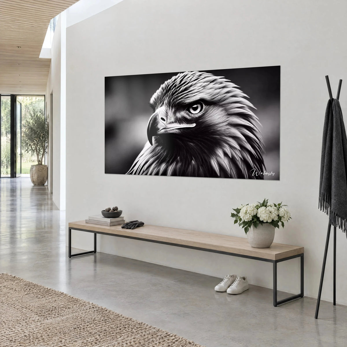 Gemälde Greifvogel in Schwarzweiß, runde Augen mit weißem Rand und dichtes anthrazitgraues Gefieder, helle Wand, Holzbank