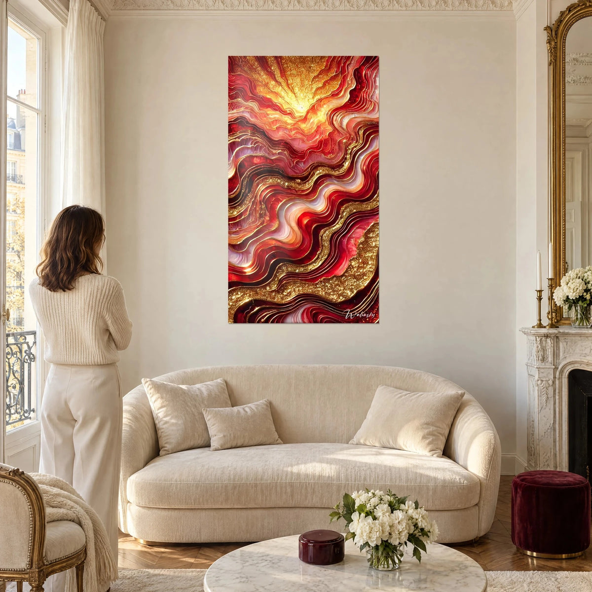 Schilderij met rode en gouden golven, gele gloed bovenaan, vrouw van achteren, boven een bank in een lichte woonkamer